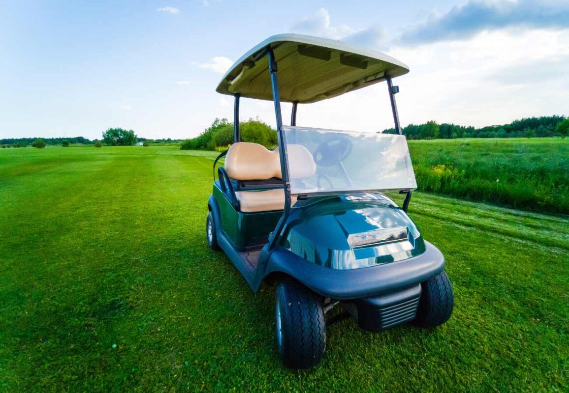 a green golf buggy on a golf course